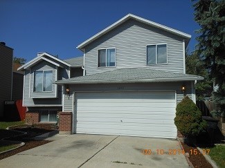 A house with a garage door and a driveway.