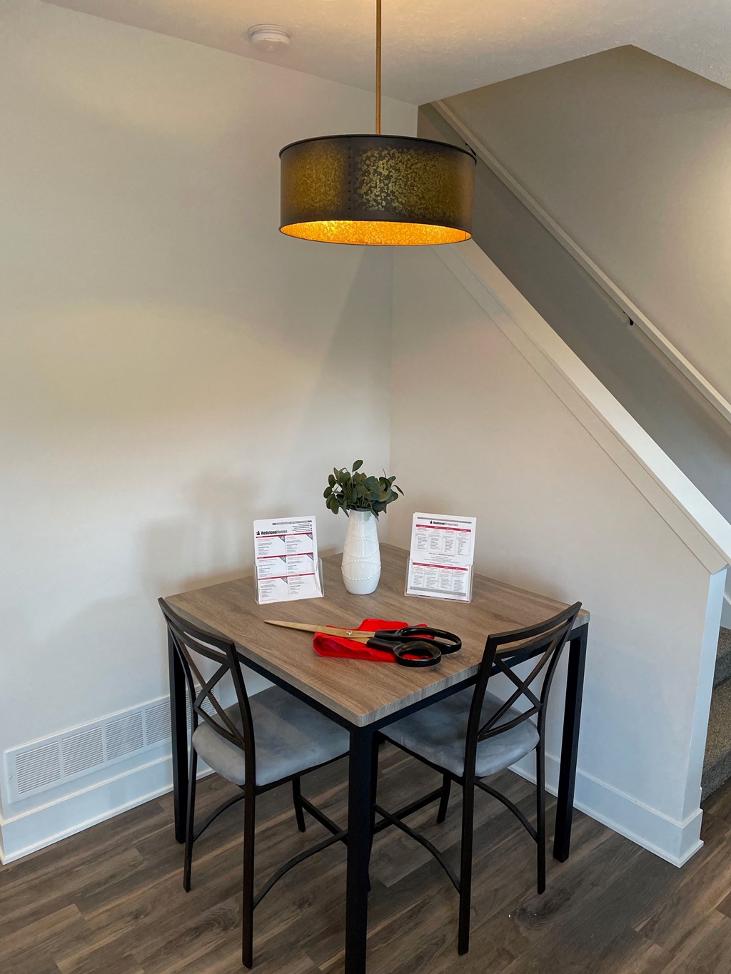 a small dining room with a wooden table and black stools