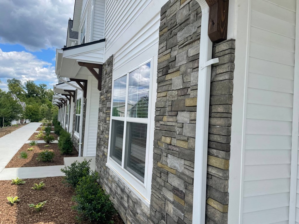 a view of the side of a house with a sidewalk