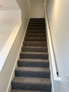 a set of stairs with grey carpet and white walls