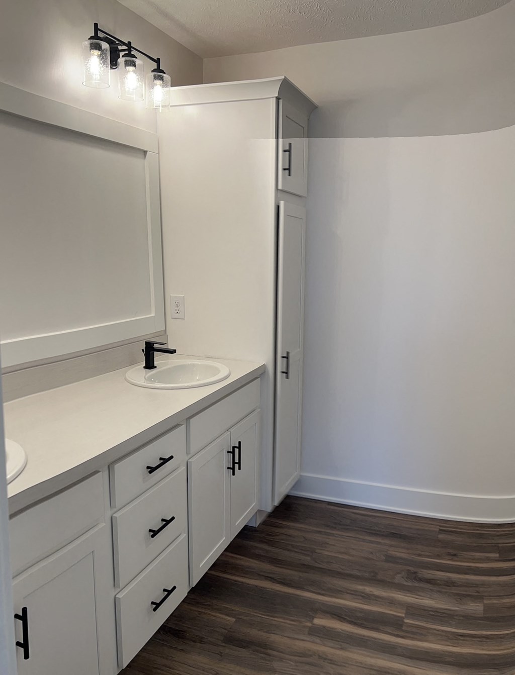 a bathroom with white cabinets and a sink and a mirror