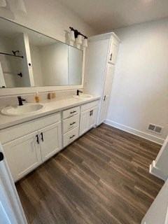 a bathroom with white cabinets and a sink and a mirror