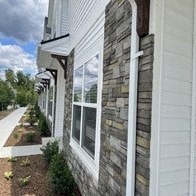 the side of a building with windows and a sidewalk