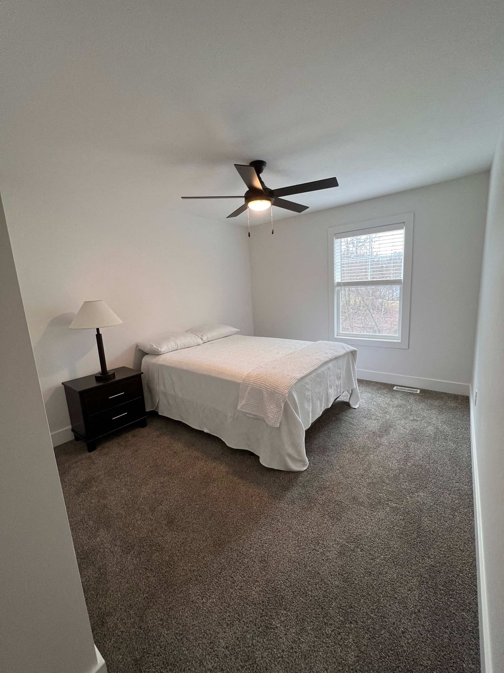 a bedroom with a bed and a ceiling fan