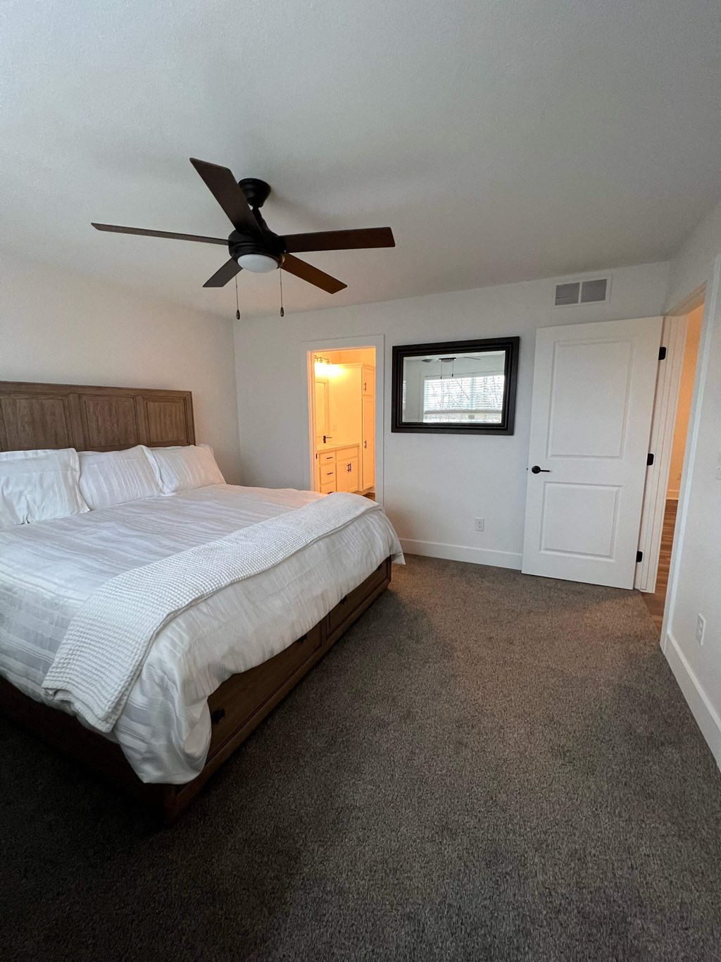 a bedroom with a bed and a ceiling fan