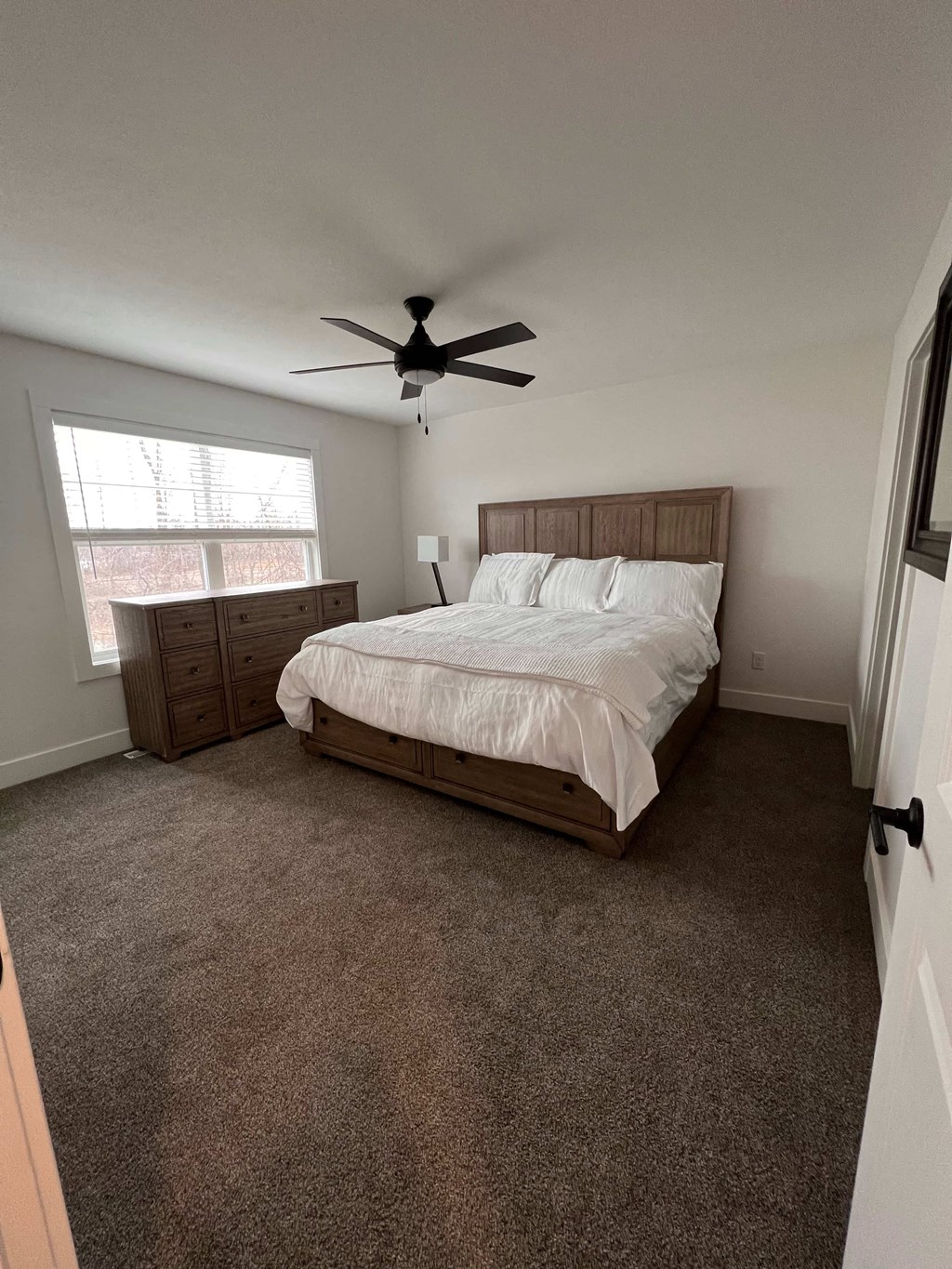 a bedroom with a bed and a ceiling fan
