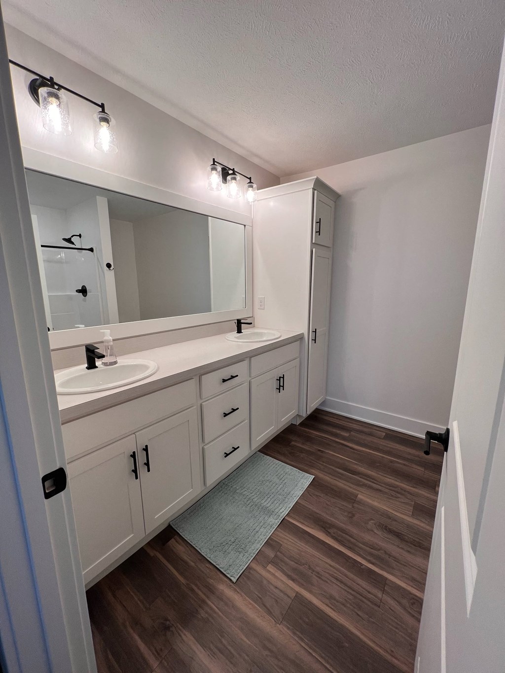 a bathroom with white cabinets and a sink and a mirror