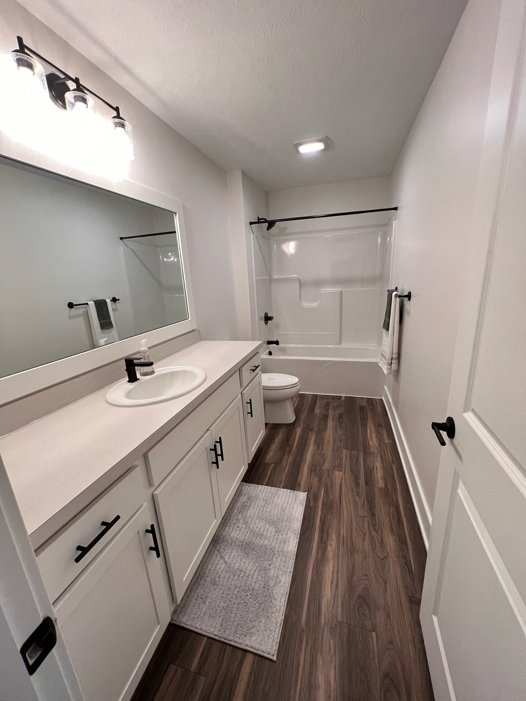 a bathroom with white cabinets and a sink and a toilet
