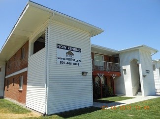 A white house with a sign that says "Now Renting" on the side.