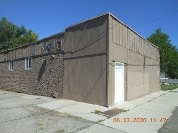 A building with a brown facade and a white door is pictured.