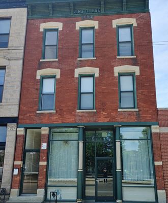 the front of a brick building with glass doors