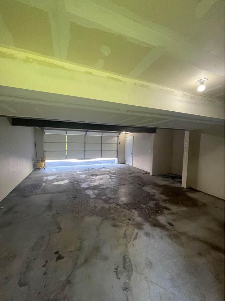 an empty garage with a concrete floor and a garage door