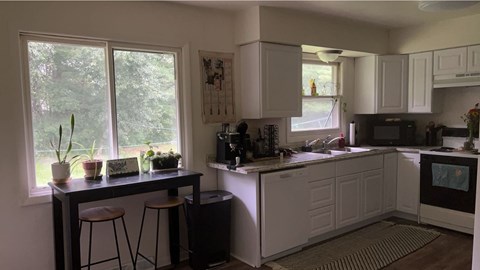A kitchen with white cabinets and a black countertop.