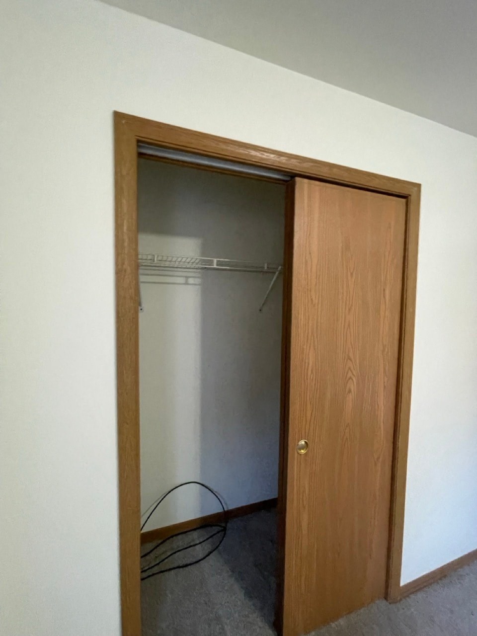 a closet in a white room with a wooden door