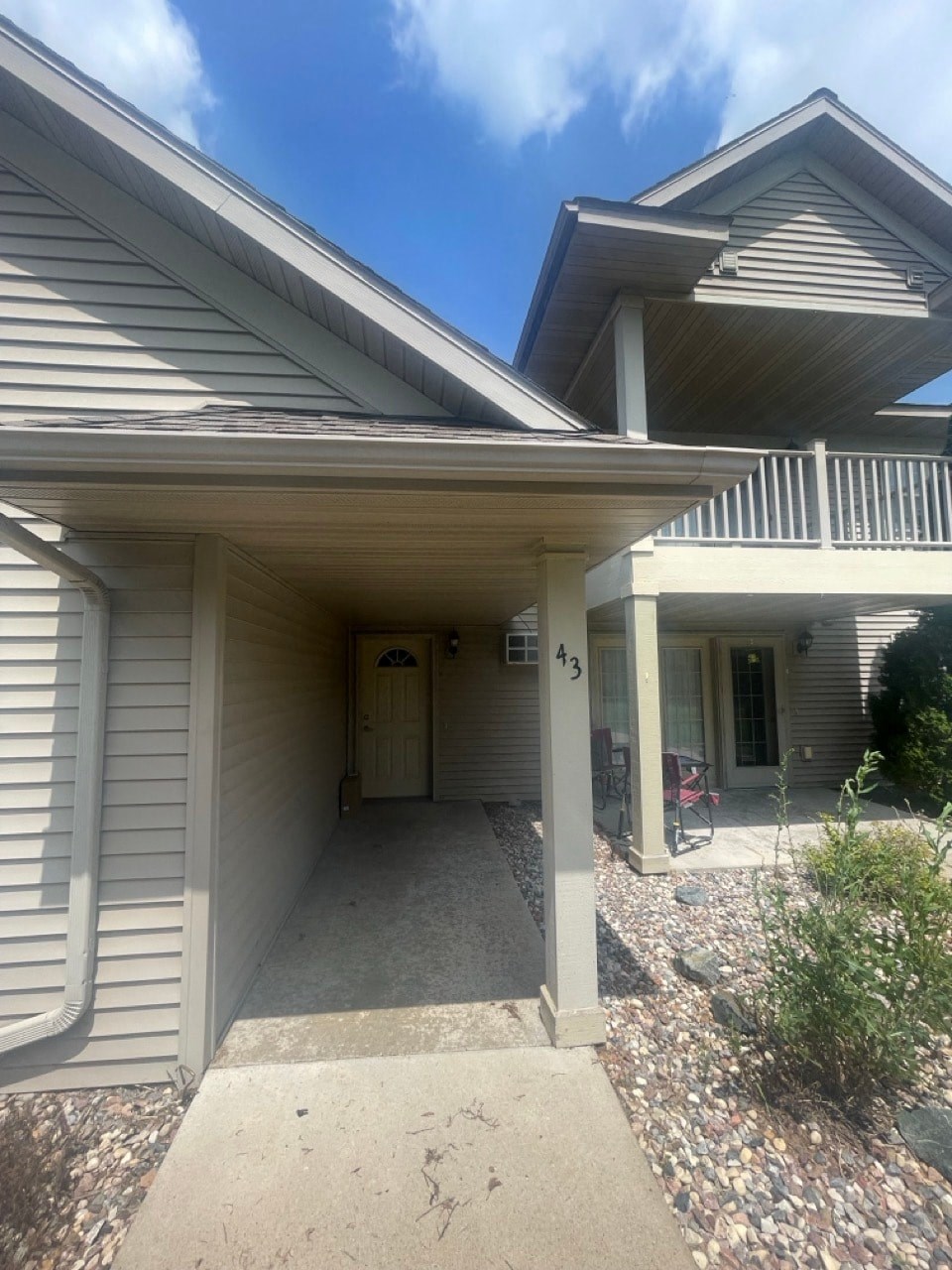 the front of a white house with a covered porch