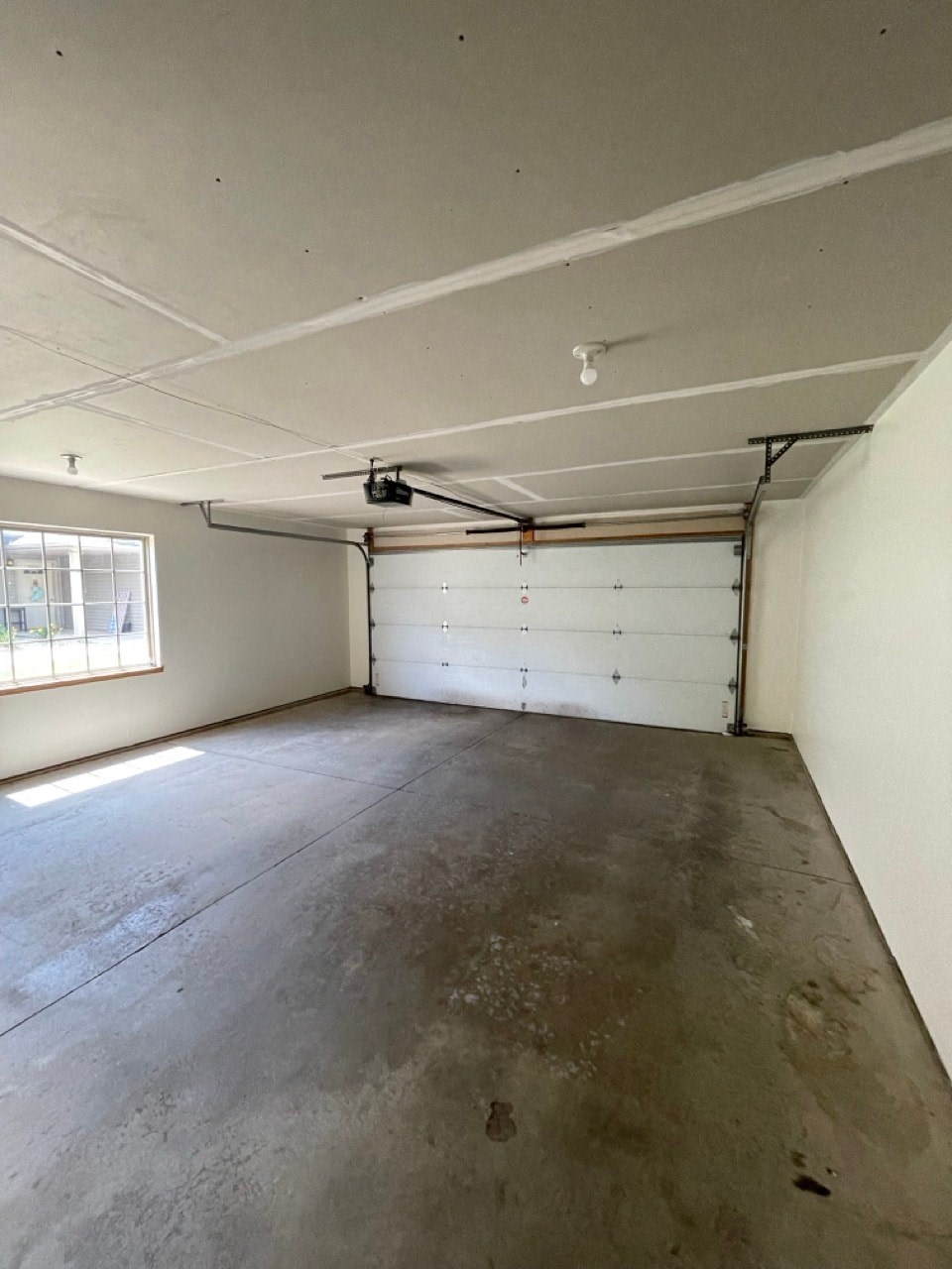 the inside of a garage with a white wall and a window