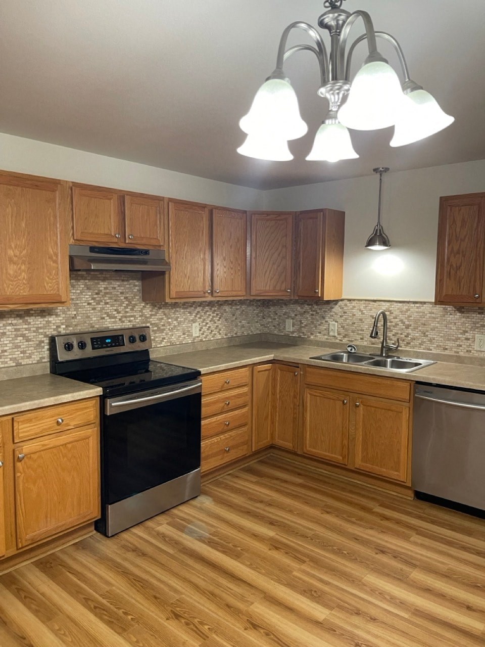 a kitchen with wooden cabinets and a stove and a sink