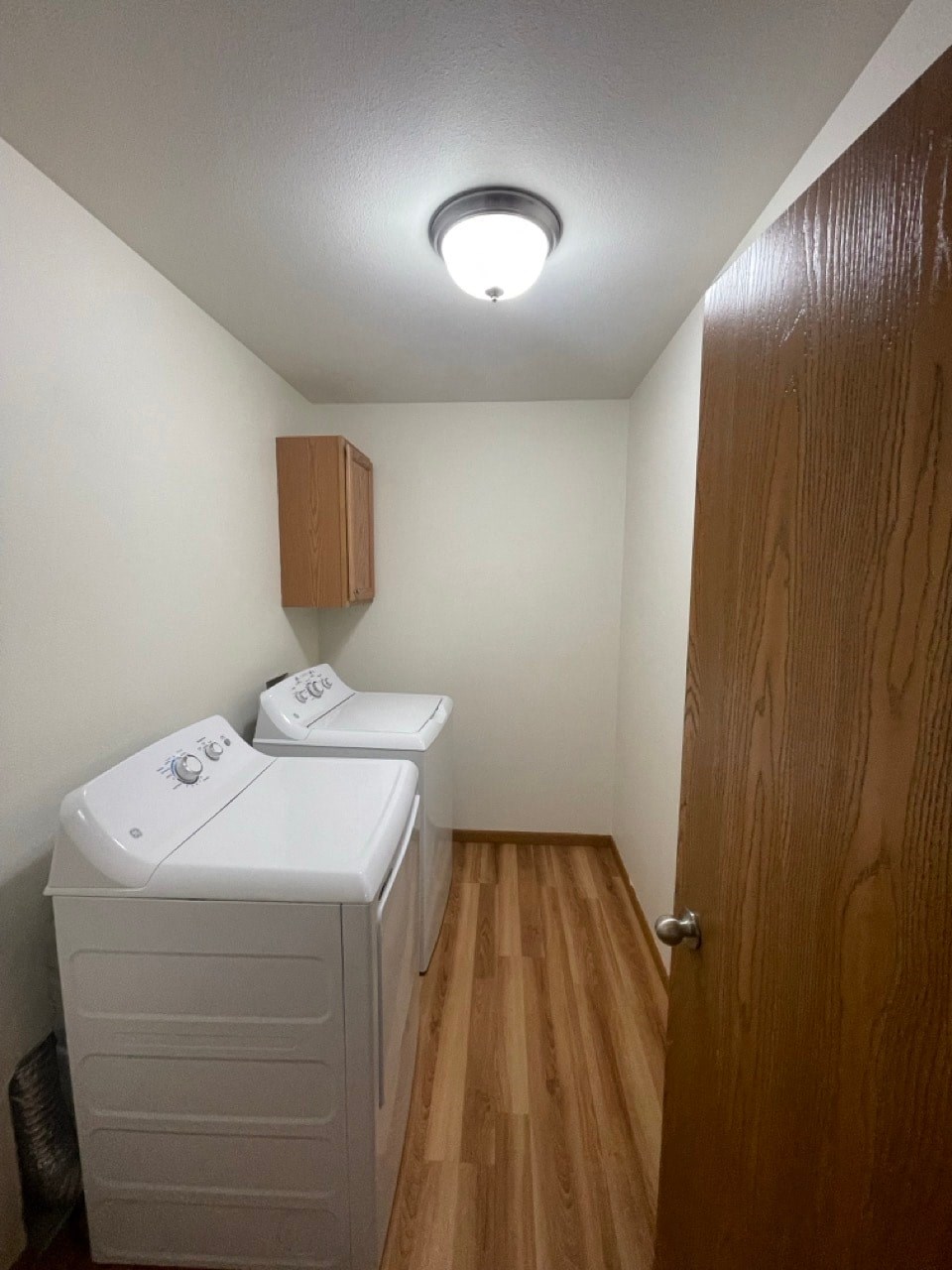 a small laundry room with two washers and a dryer