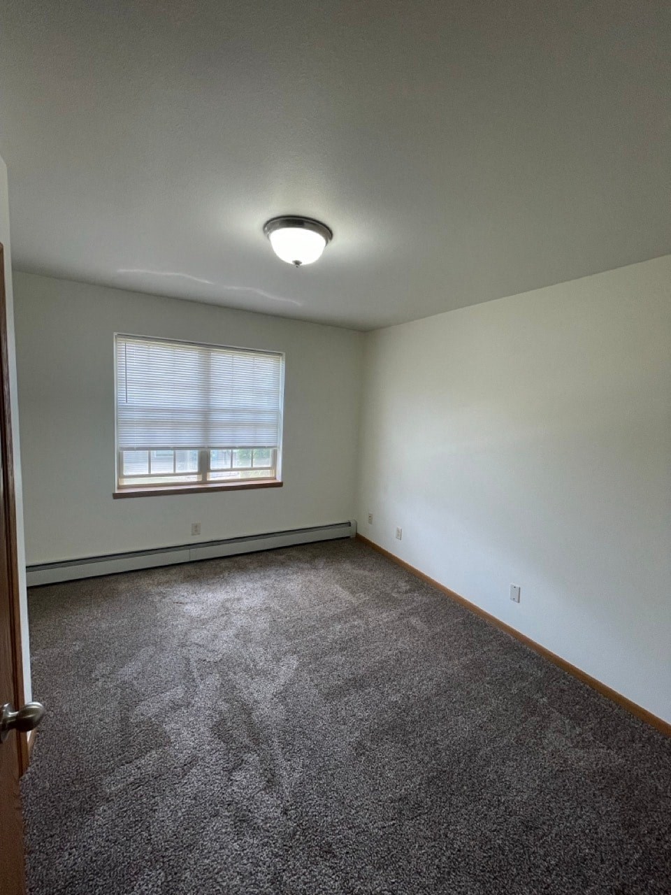 an empty room with carpet and a window