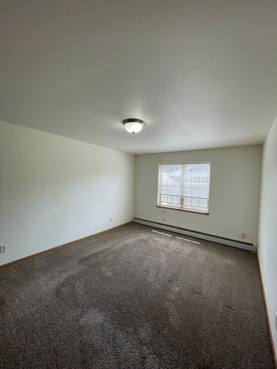 an empty room with carpet and a window