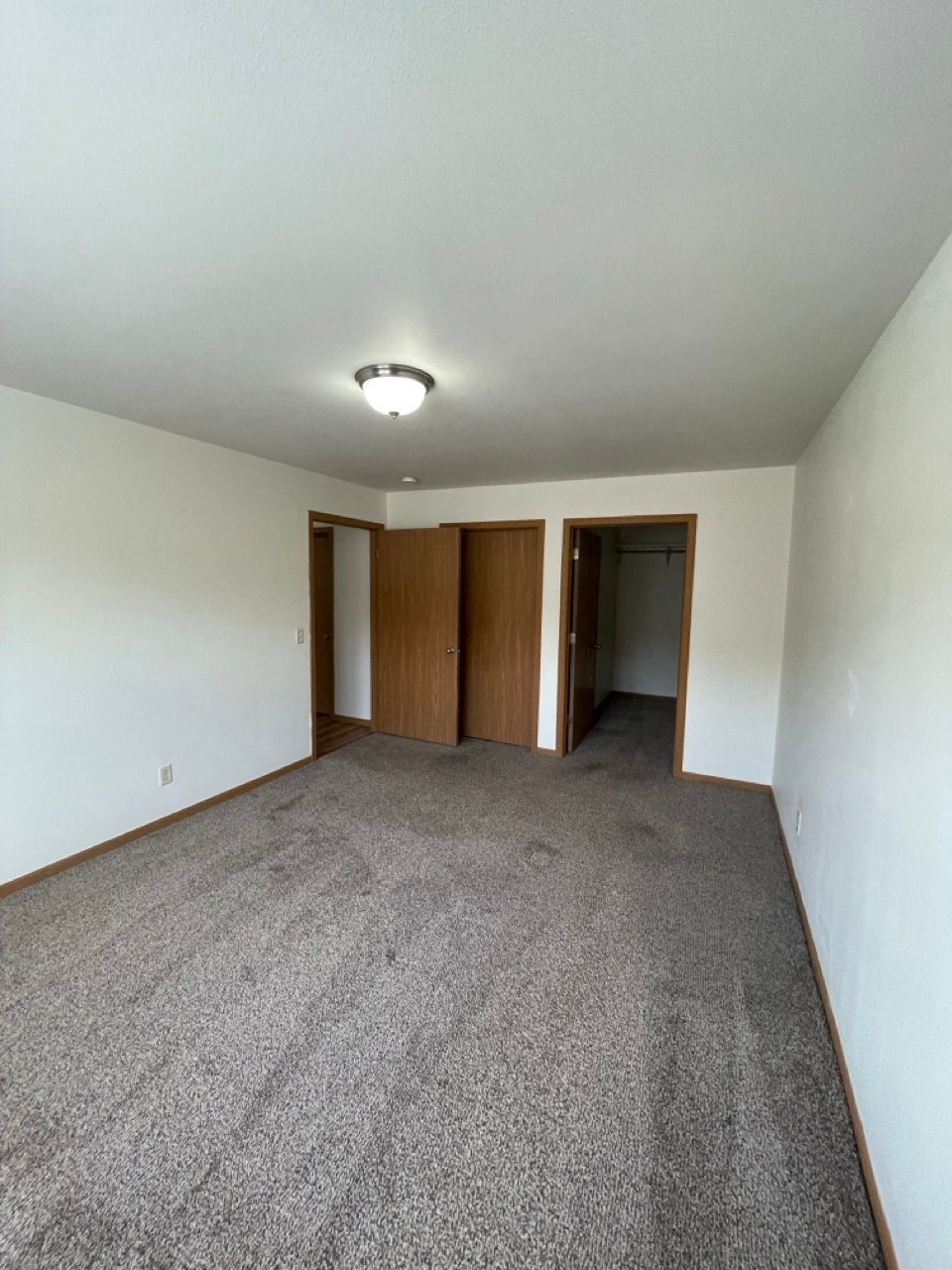 an empty living room with carpet and white walls
