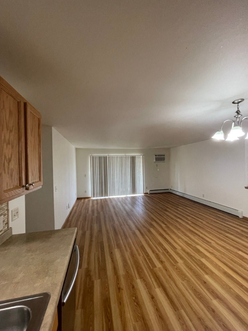 an empty kitchen and living room with wood flooring