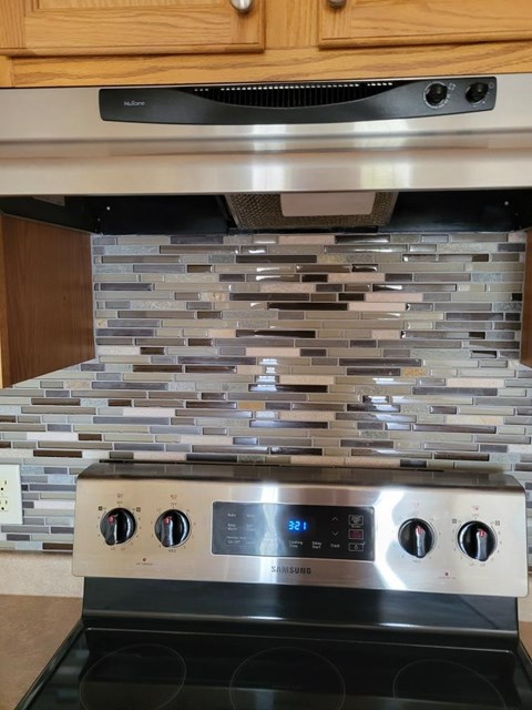 A Samsung stove top oven with a digital display and four burners.