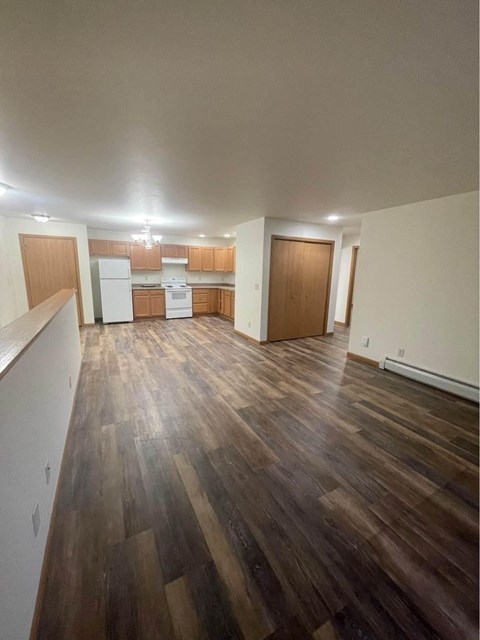 A kitchen with wooden floors and white appliances.