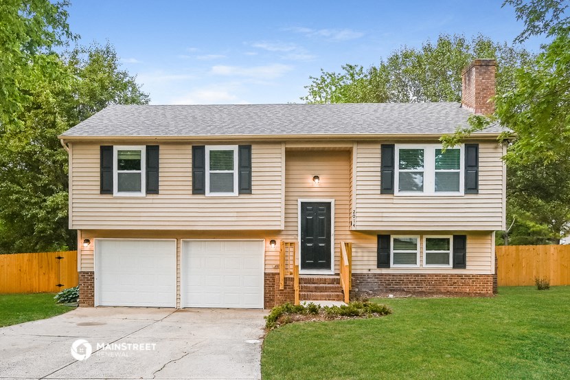 a tan house with black shutters and a white garage door