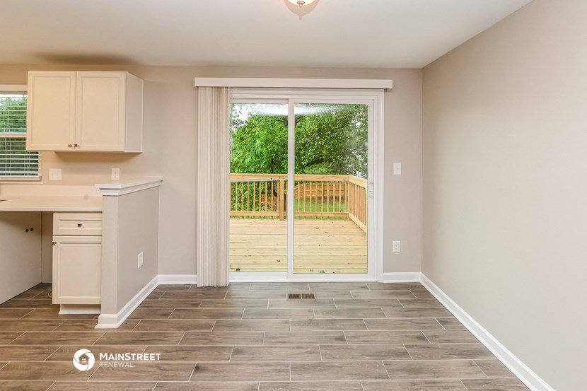 an empty kitchen with a sliding glass door to a deck