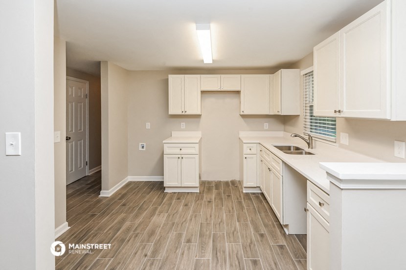 an empty kitchen with white cabinets and white counter tops