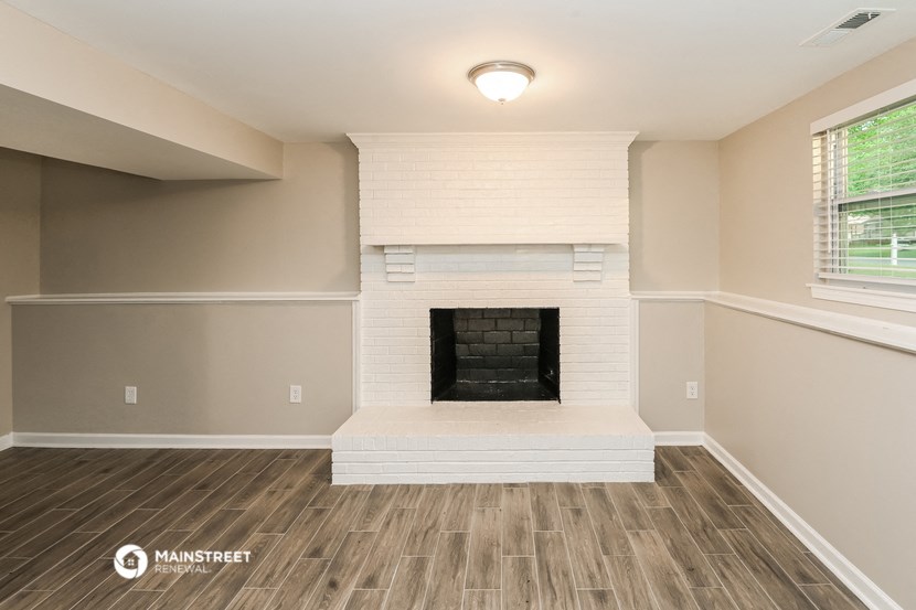 the upstairs living room with fireplace and wood flooring