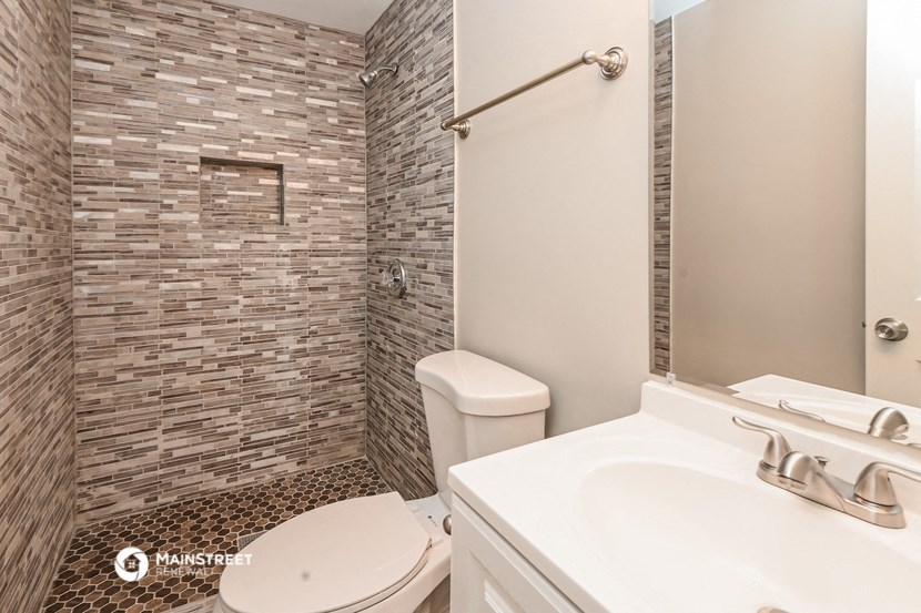 a bathroom with a toilet and a shower and a sink