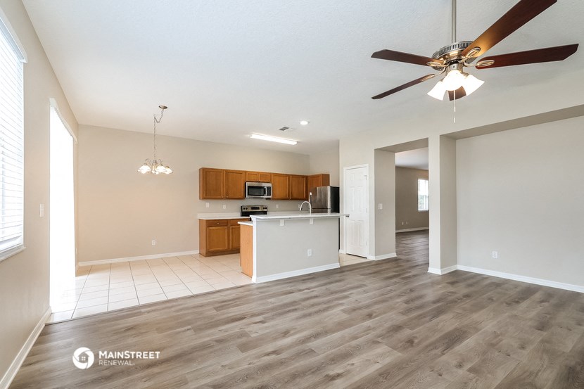 an open kitchen and living room with a ceiling fan