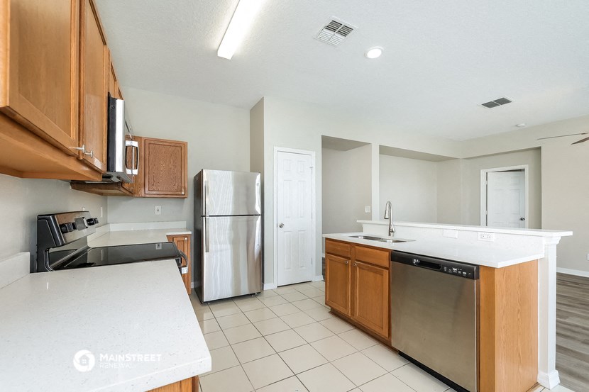 a kitchen with wooden cabinets and a stainless steel refrigerator