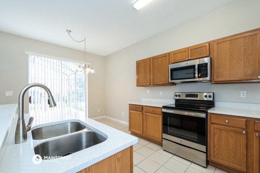 a kitchen with wooden cabinets and stainless steel appliances