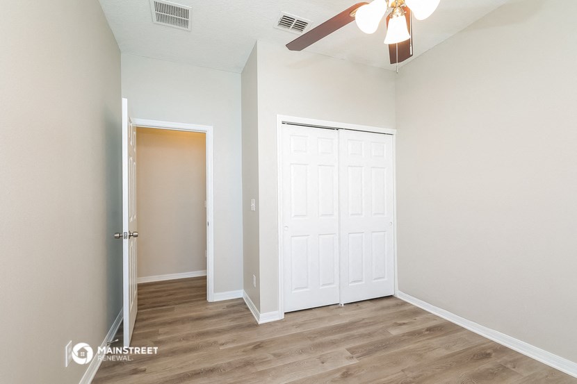 a bedroom with a closet and a ceiling fan