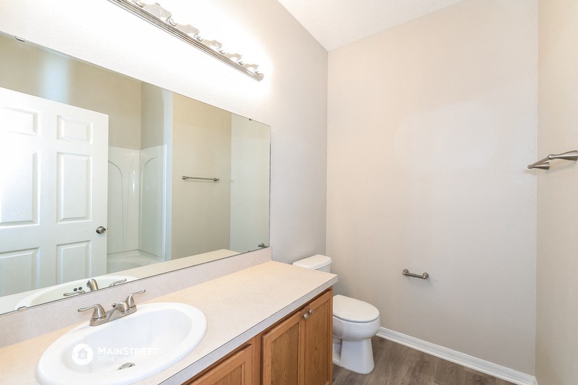a bathroom with a large mirror and a sink and a toilet