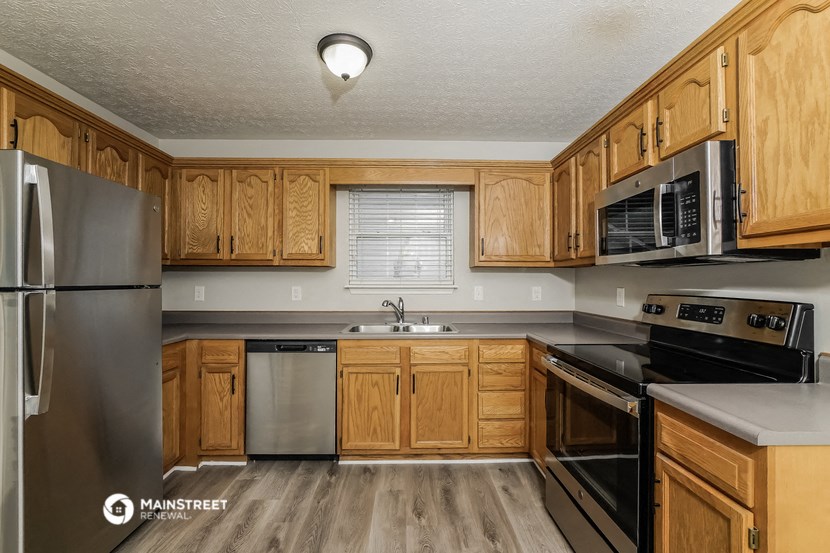 a kitchen with wooden cabinets and stainless steel appliances