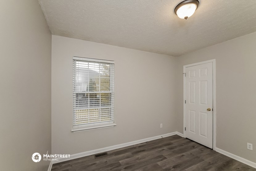 the interior of a bedroom with a window and a white door