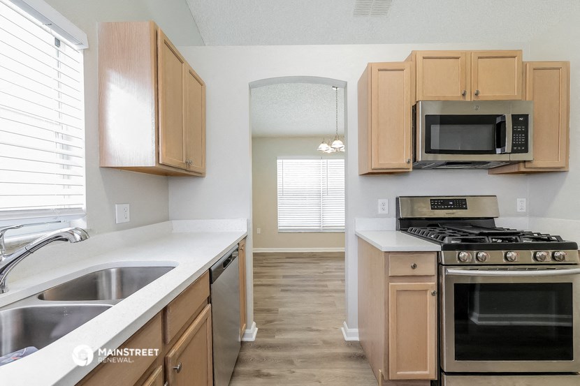 a kitchen with wooden cabinets and stainless steel appliances
