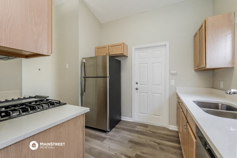 a kitchen with wooden cabinets and a stainless steel refrigerator