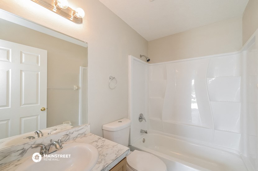a bathroom with a white tub and a sink and a toilet