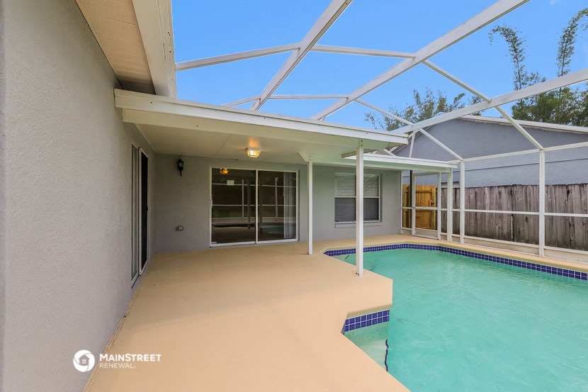 a covered patio with a swimming pool and glass doors