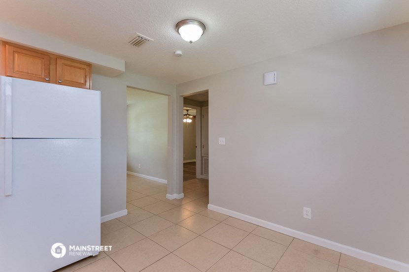 a kitchen with a refrigerator and a door to a hallway