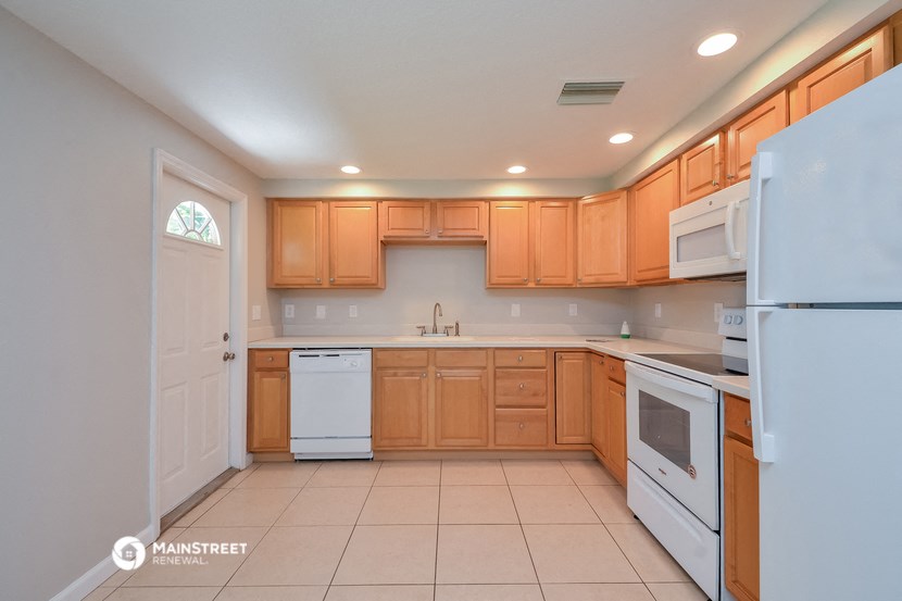 a large kitchen with white appliances and wooden cabinets