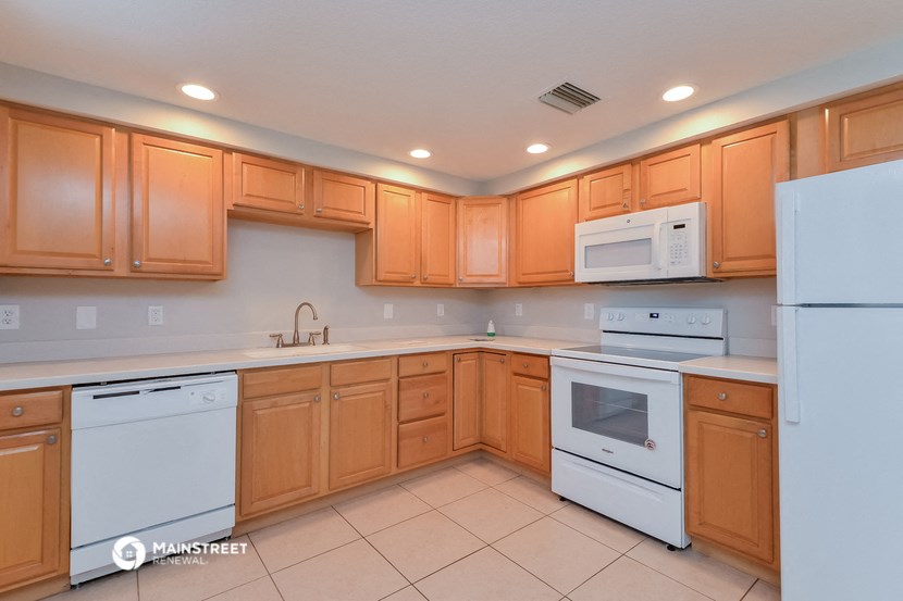a kitchen with white appliances and wooden cabinets