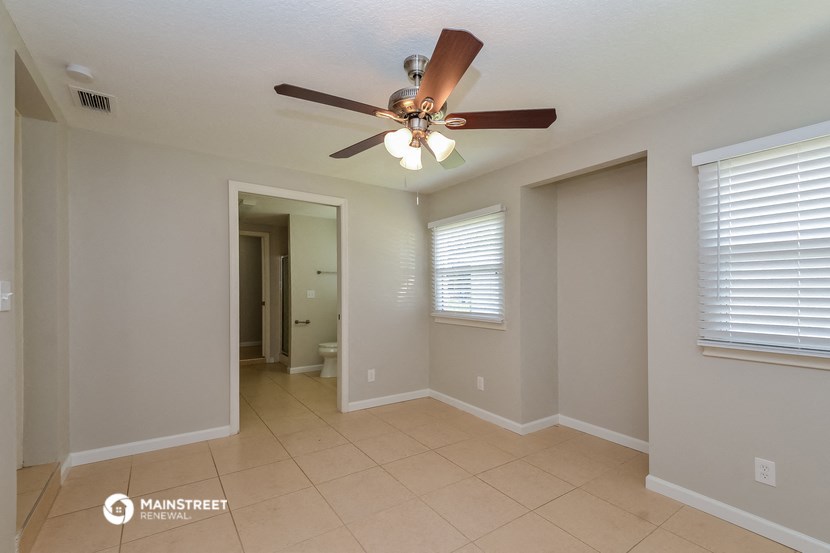 the living room has a ceiling fan and a tiled floor