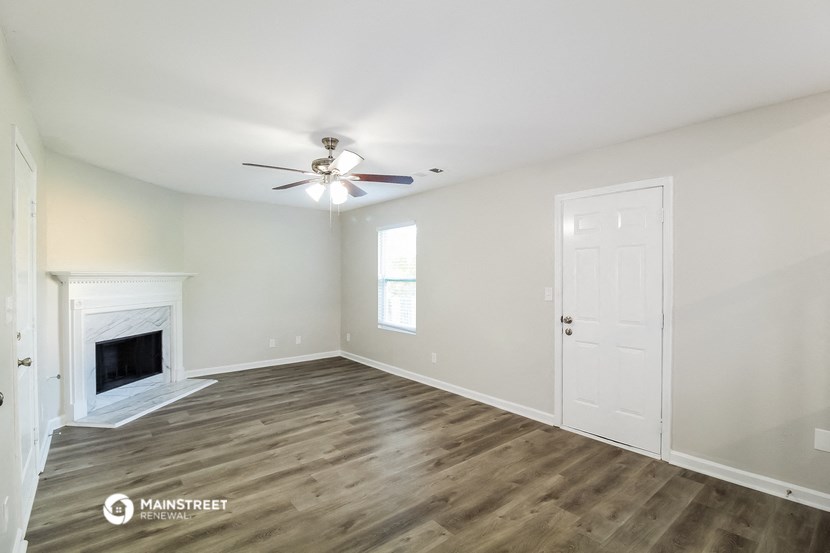 the living room with fireplace and ceiling fan