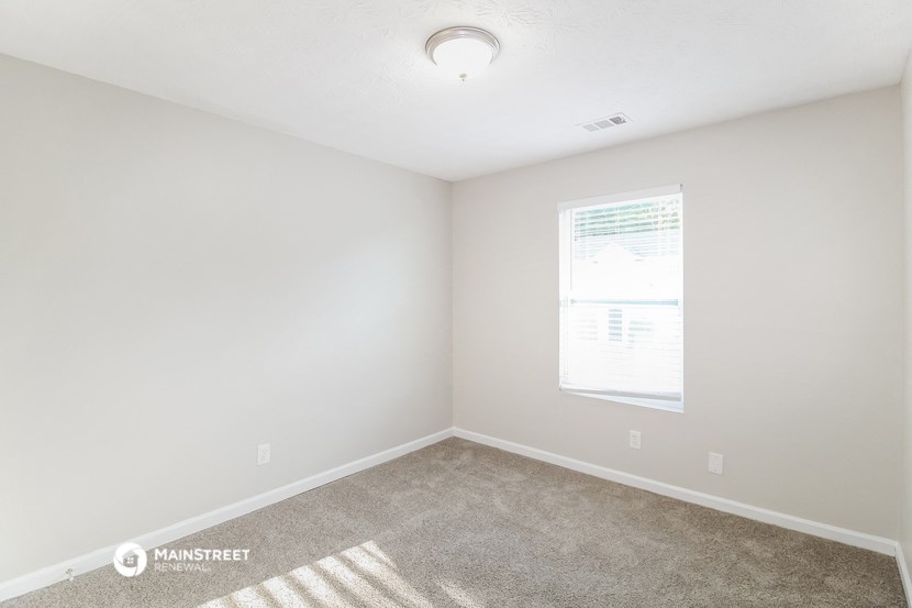 an empty room with carpet and a window